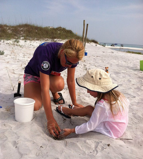 2.AmeriCorps NWF Environmental Steward member teaching children to plant sea oats as part of a dune restoration project at Topsail Hill State Park.